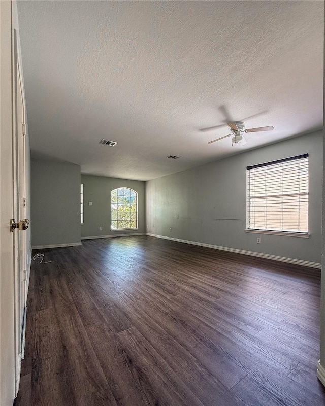 unfurnished room with ceiling fan, a textured ceiling, and dark hardwood / wood-style flooring