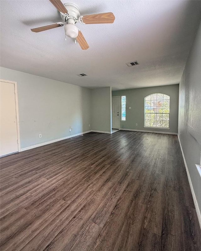 unfurnished room featuring ceiling fan, dark wood-type flooring, and a textured ceiling