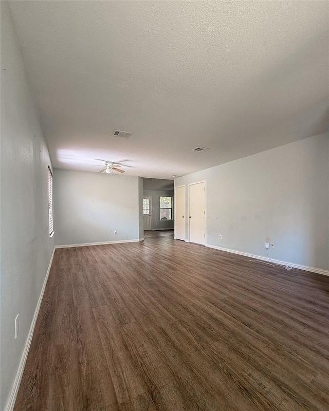 spare room featuring a textured ceiling, dark wood-type flooring, and ceiling fan