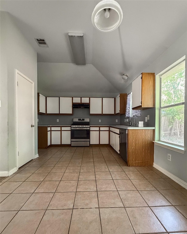 kitchen with light tile patterned floors, dishwasher, white cabinets, and stainless steel gas range oven