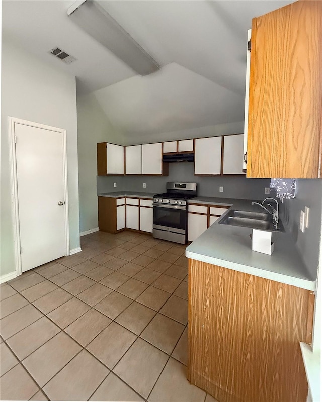 kitchen with stainless steel gas range, light tile patterned floors, white cabinets, and sink