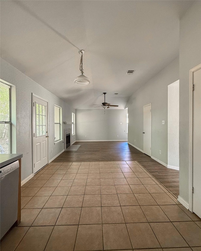 unfurnished living room featuring ceiling fan, light tile patterned floors, and a wealth of natural light