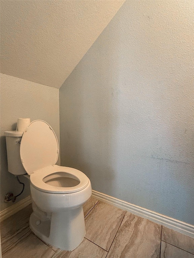 bathroom featuring vaulted ceiling and toilet