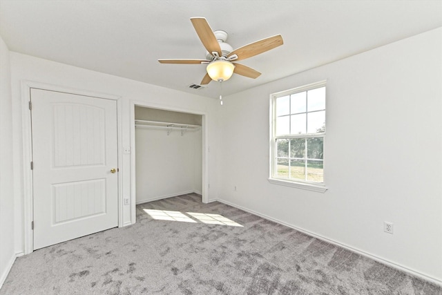 unfurnished bedroom featuring light carpet, ceiling fan, and a closet