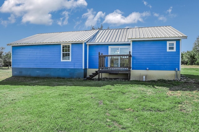 back of property with a lawn and a deck