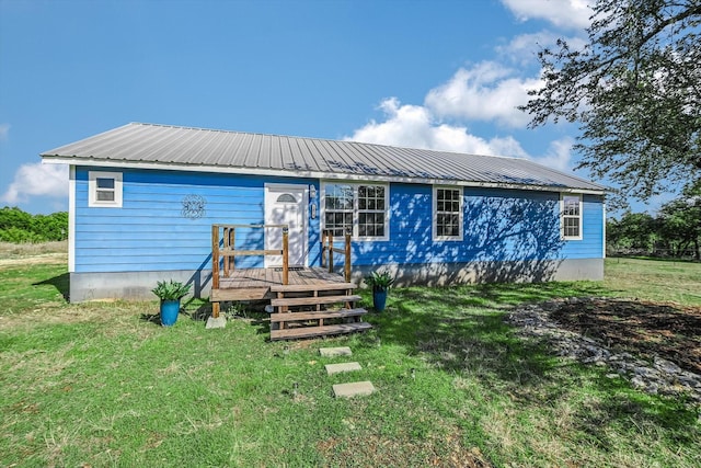 rear view of house featuring a lawn