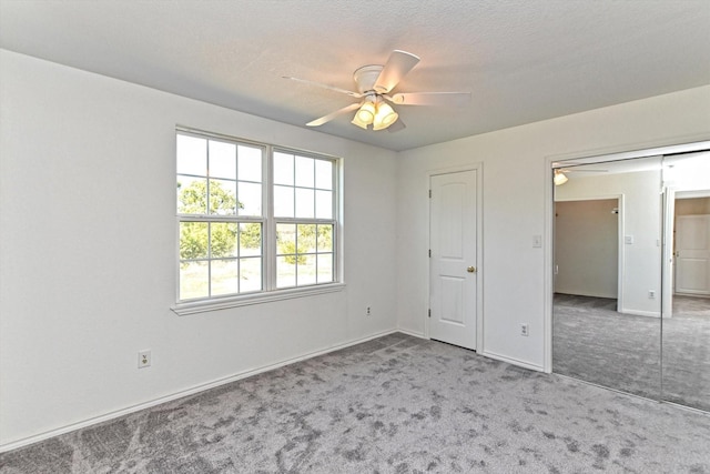 unfurnished bedroom with a textured ceiling, ceiling fan, and carpet