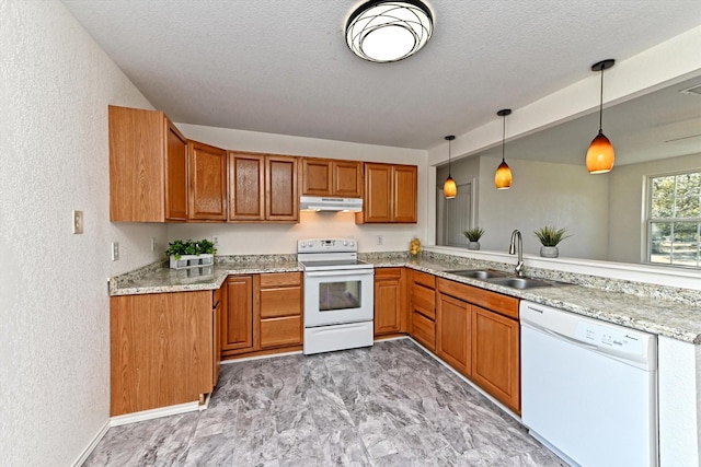 kitchen with kitchen peninsula, white appliances, hanging light fixtures, light stone countertops, and sink