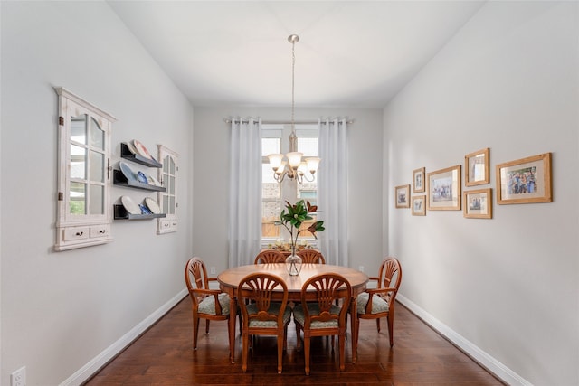 dining space with a wealth of natural light, a chandelier, and dark hardwood / wood-style flooring