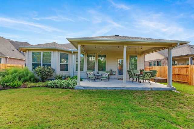 back of property with a patio area and a yard