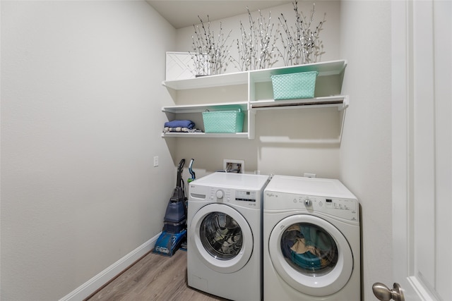 laundry area with washing machine and dryer and light hardwood / wood-style flooring