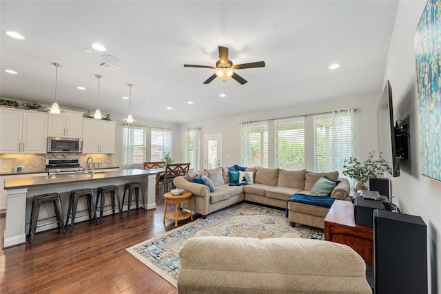 living room with ceiling fan, dark wood-type flooring, and sink