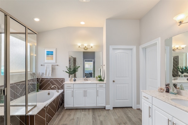 bathroom featuring hardwood / wood-style floors, vanity, and plus walk in shower