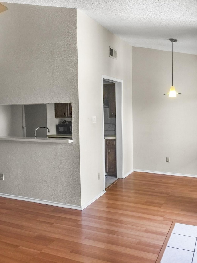 kitchen featuring hardwood / wood-style flooring and a textured ceiling