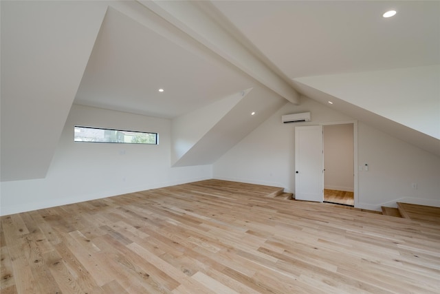 additional living space featuring light hardwood / wood-style floors, lofted ceiling with beams, and a wall mounted air conditioner