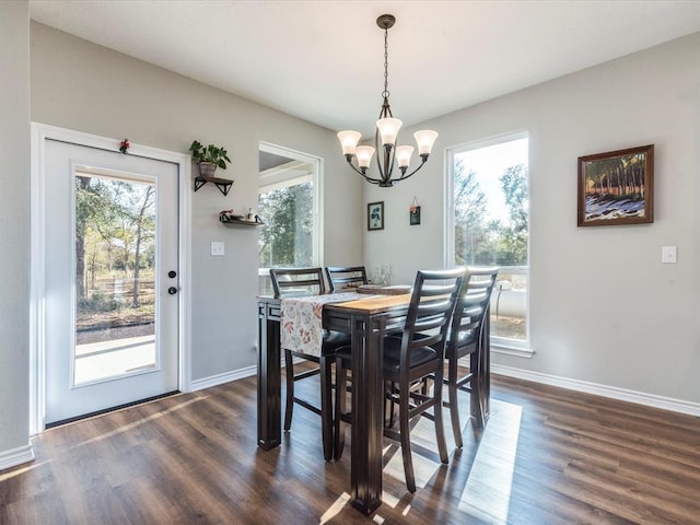 dining area featuring plenty of natural light, dark hardwood / wood-style floors, and a notable chandelier