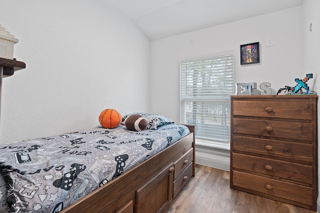 bedroom with wood-type flooring and vaulted ceiling