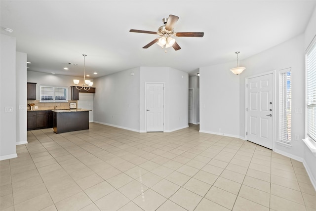 unfurnished living room featuring light tile patterned floors and ceiling fan with notable chandelier