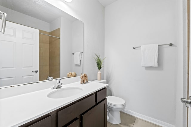 bathroom featuring toilet, vanity, tile patterned floors, and a tile shower