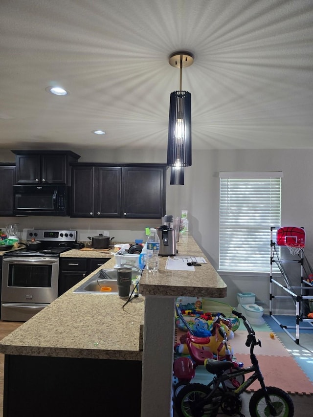 kitchen with sink, stainless steel electric range, and decorative light fixtures