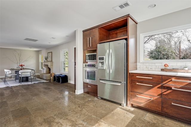 kitchen with decorative backsplash and appliances with stainless steel finishes