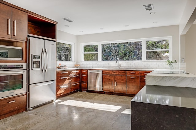 kitchen with backsplash, sink, and stainless steel appliances