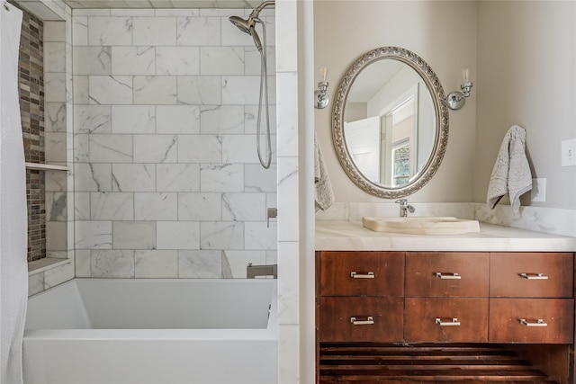 bathroom with tiled shower / bath combo and vanity