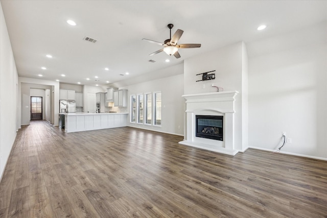 unfurnished living room with ceiling fan and dark hardwood / wood-style flooring