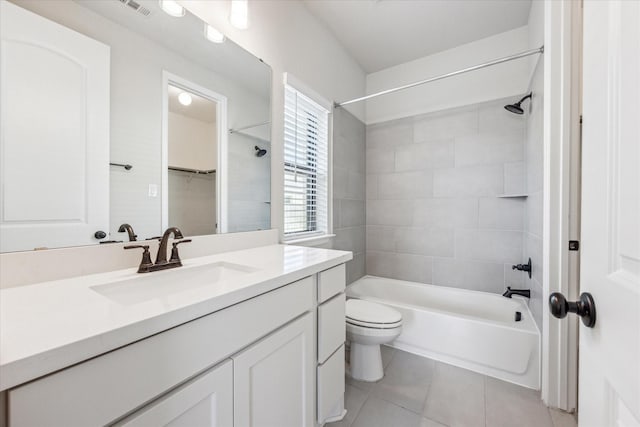 full bathroom with toilet, vanity, tile patterned flooring, and tiled shower / bath combo