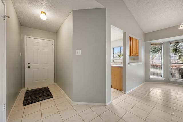 interior space featuring vaulted ceiling, light tile patterned flooring, and a textured ceiling