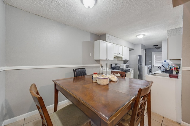 tiled dining area featuring sink and a textured ceiling