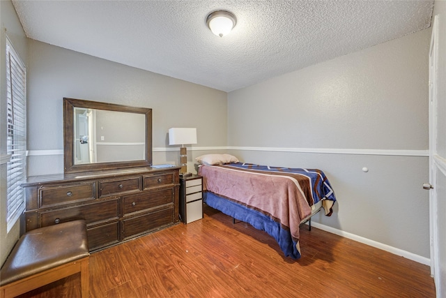 bedroom featuring hardwood / wood-style floors and a textured ceiling