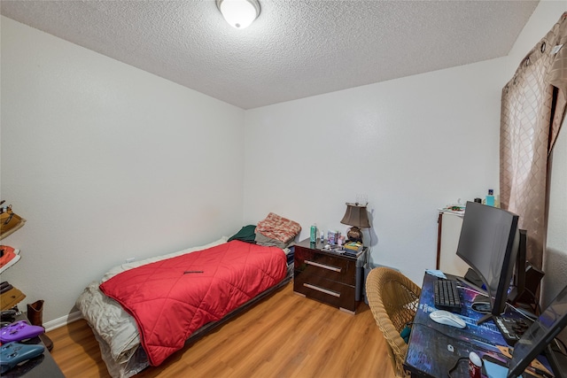 bedroom featuring wood-type flooring and a textured ceiling