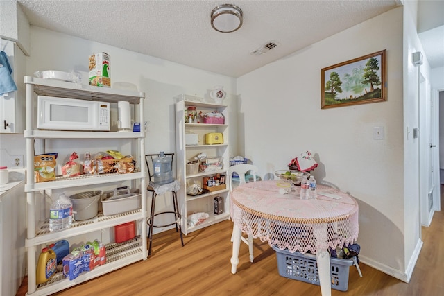 playroom featuring a textured ceiling and hardwood / wood-style floors