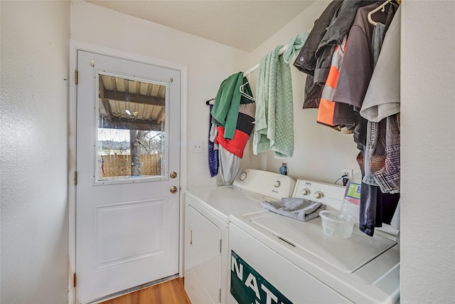 washroom with light hardwood / wood-style flooring and washing machine and clothes dryer