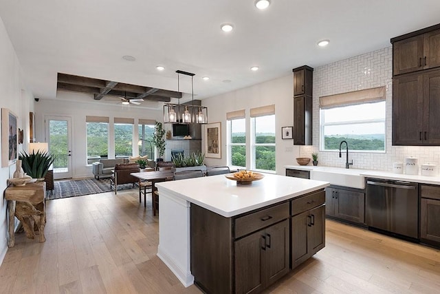 kitchen with ceiling fan, black dishwasher, light wood-type flooring, beam ceiling, and sink