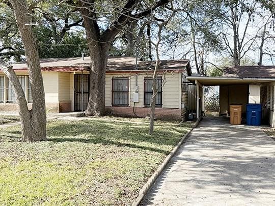 view of front of property with a front lawn and a carport