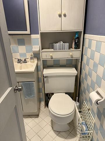 bathroom with toilet, vanity, and tile patterned floors