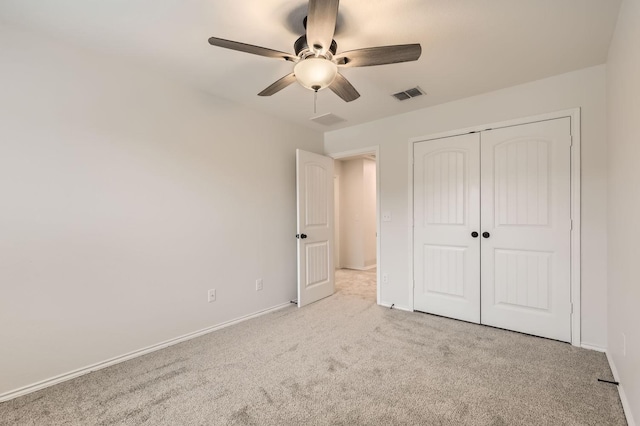 unfurnished bedroom featuring ceiling fan, light colored carpet, and a closet