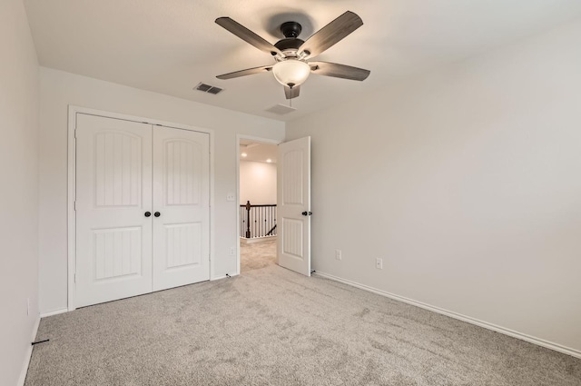 unfurnished bedroom featuring light colored carpet, ceiling fan, and a closet