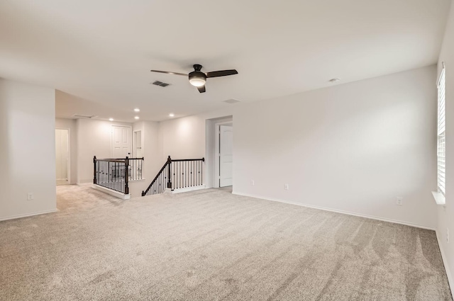 unfurnished living room featuring light colored carpet and ceiling fan