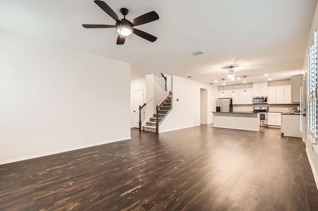 unfurnished living room with ceiling fan and dark hardwood / wood-style flooring