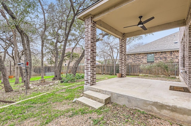 view of yard with ceiling fan and a patio