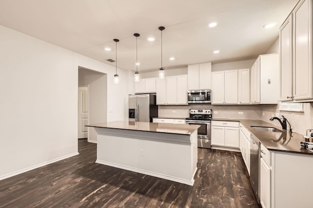 kitchen featuring a kitchen island, appliances with stainless steel finishes, sink, and white cabinets