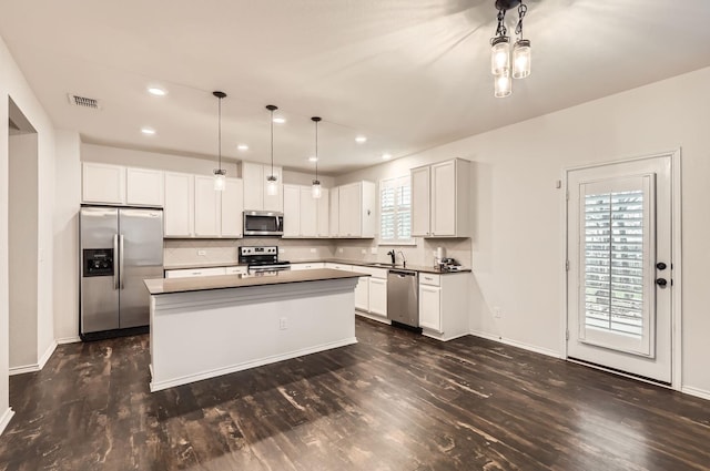 kitchen featuring sink, white cabinetry, a center island, pendant lighting, and stainless steel appliances