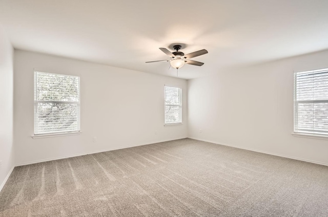 carpeted spare room featuring ceiling fan