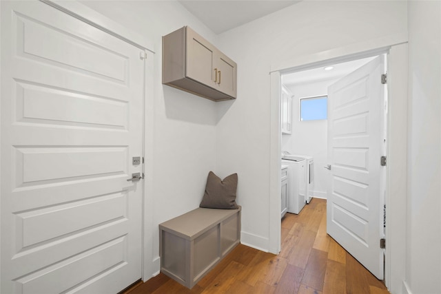 mudroom with hardwood / wood-style floors and independent washer and dryer