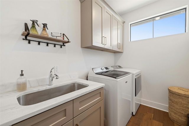 laundry area with cabinets, dark hardwood / wood-style floors, sink, and independent washer and dryer