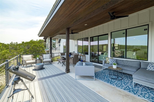 wooden terrace featuring an outdoor living space and ceiling fan