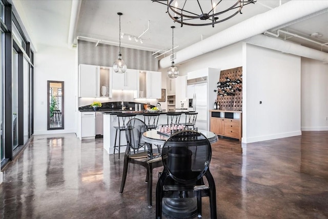 dining space featuring a chandelier, a high ceiling, and sink